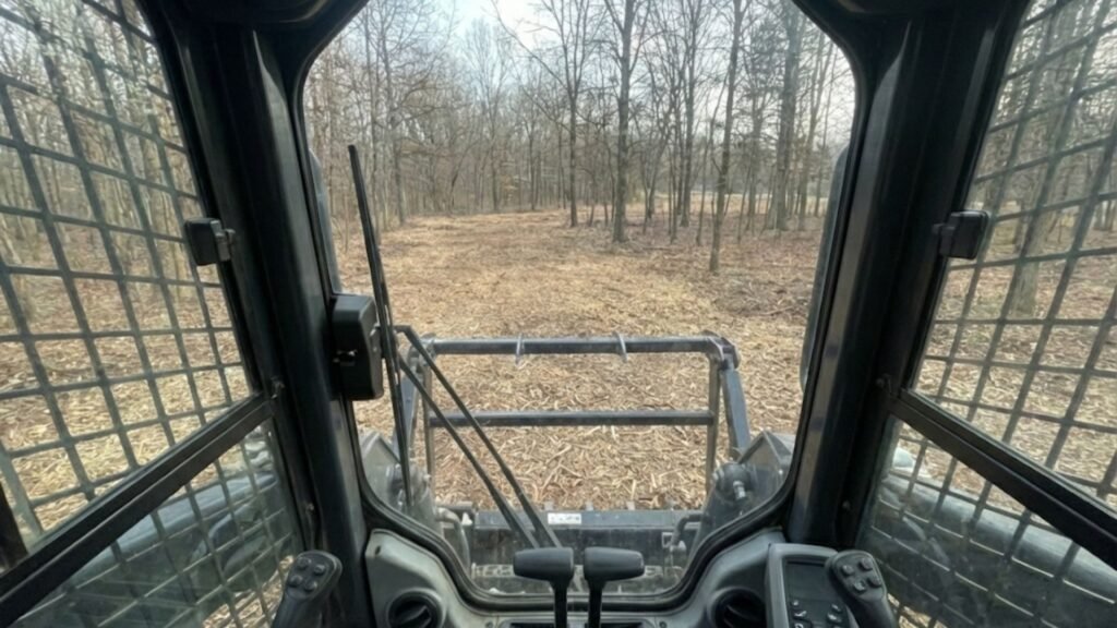 Inside Cab View of Skid Steer Clearing Woodland Brush