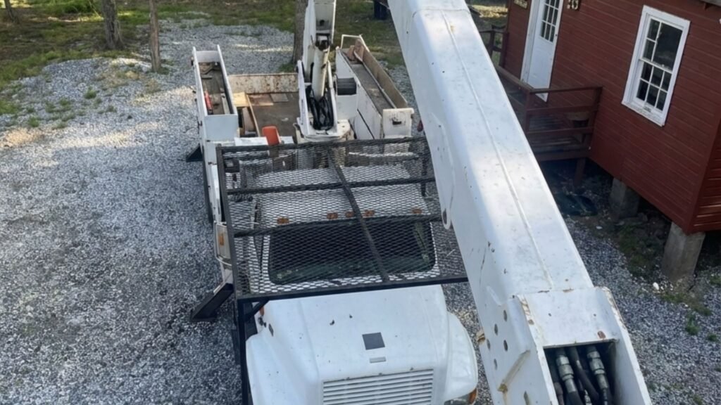 Overhead view of a bucket truck boom extended above a residential gravel lot in Seymour Connecticut