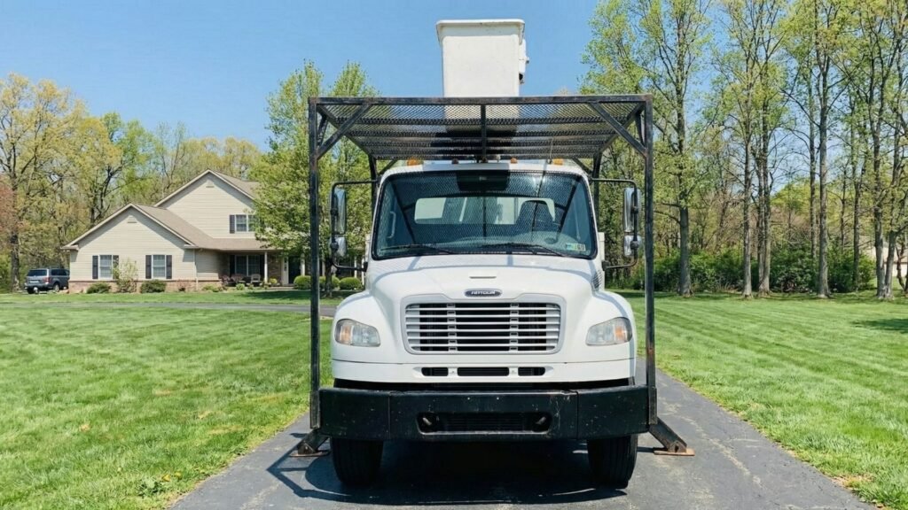 Front view of bucket truck centered on a residential driveway during tree removal in Roxbury Connecticut