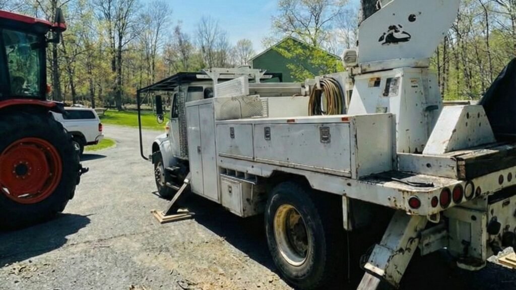 Bucket truck stabilized on driveway during residential tree removal work in Shelton Connecticut