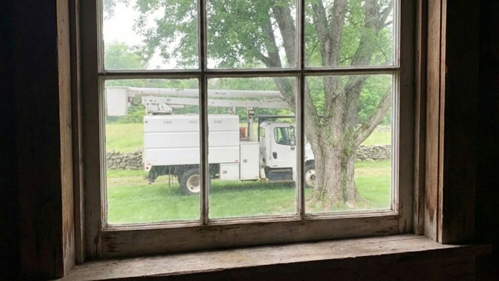 Bucket Truck Seen Through Barn Window for Tree Work Near Me in Connecticut