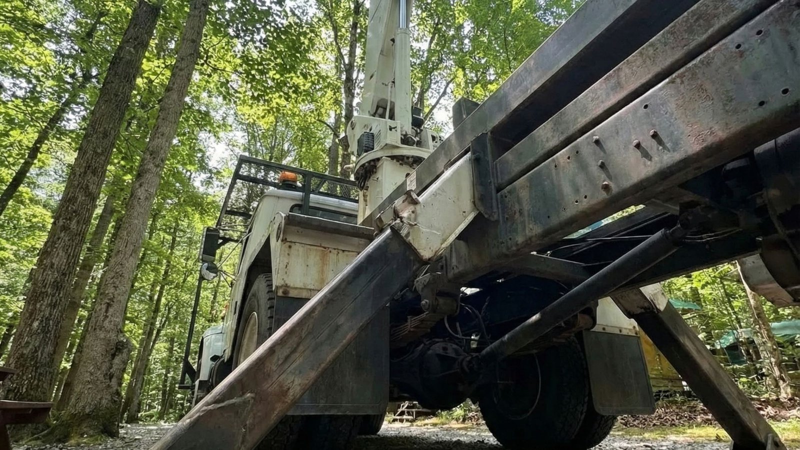 Stabilizing outrigger deployed on gravel surface during residential tree removal in Woodbury Connecticut