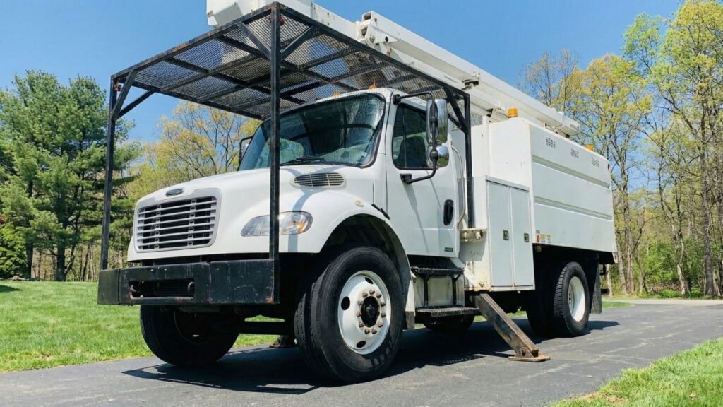 Bucket truck stabilized with outriggers on a residential driveway during tree removal in Roxbury Connecticut