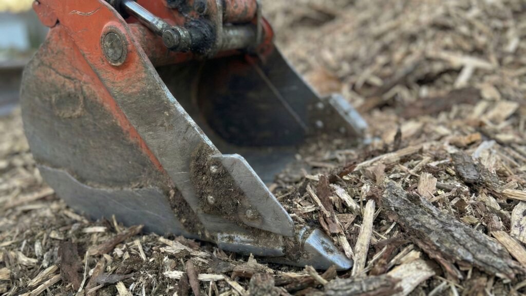 Close up of excavator bucket handling wood debris during tree removal in Seymour Connecticut