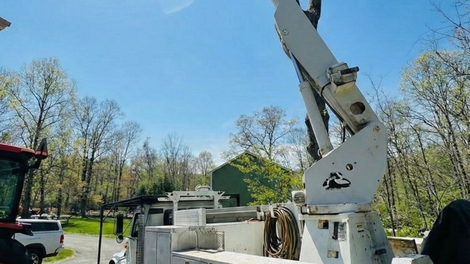 Bucket truck set up on a residential driveway for safe tree removal in Shelton Connecticut