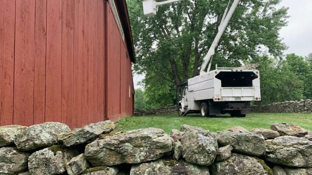 Bucket Truck Positioned for Tree Work Near Me Behind Barn in Oxford Connecticut