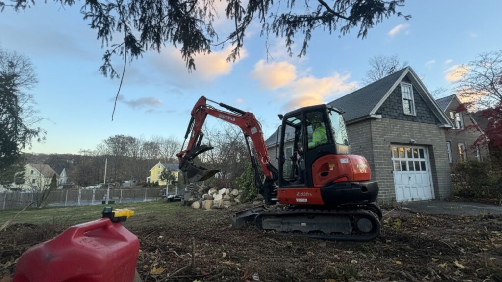 Excavator operating during residential tree removal cleanup in Shelton Connecticut
